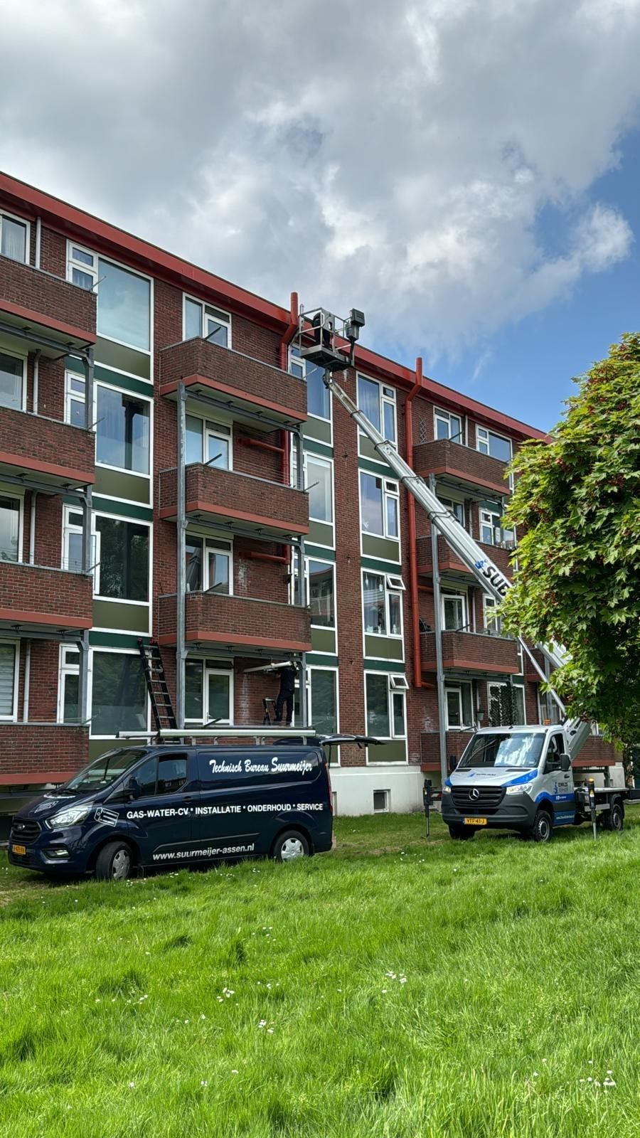 Suurmeijer monteur met hoogwerker tijdens onderhoud aan een appartementencomplex
